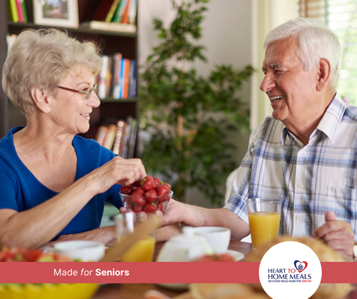 Senior women sharing fresh fruit with senior man